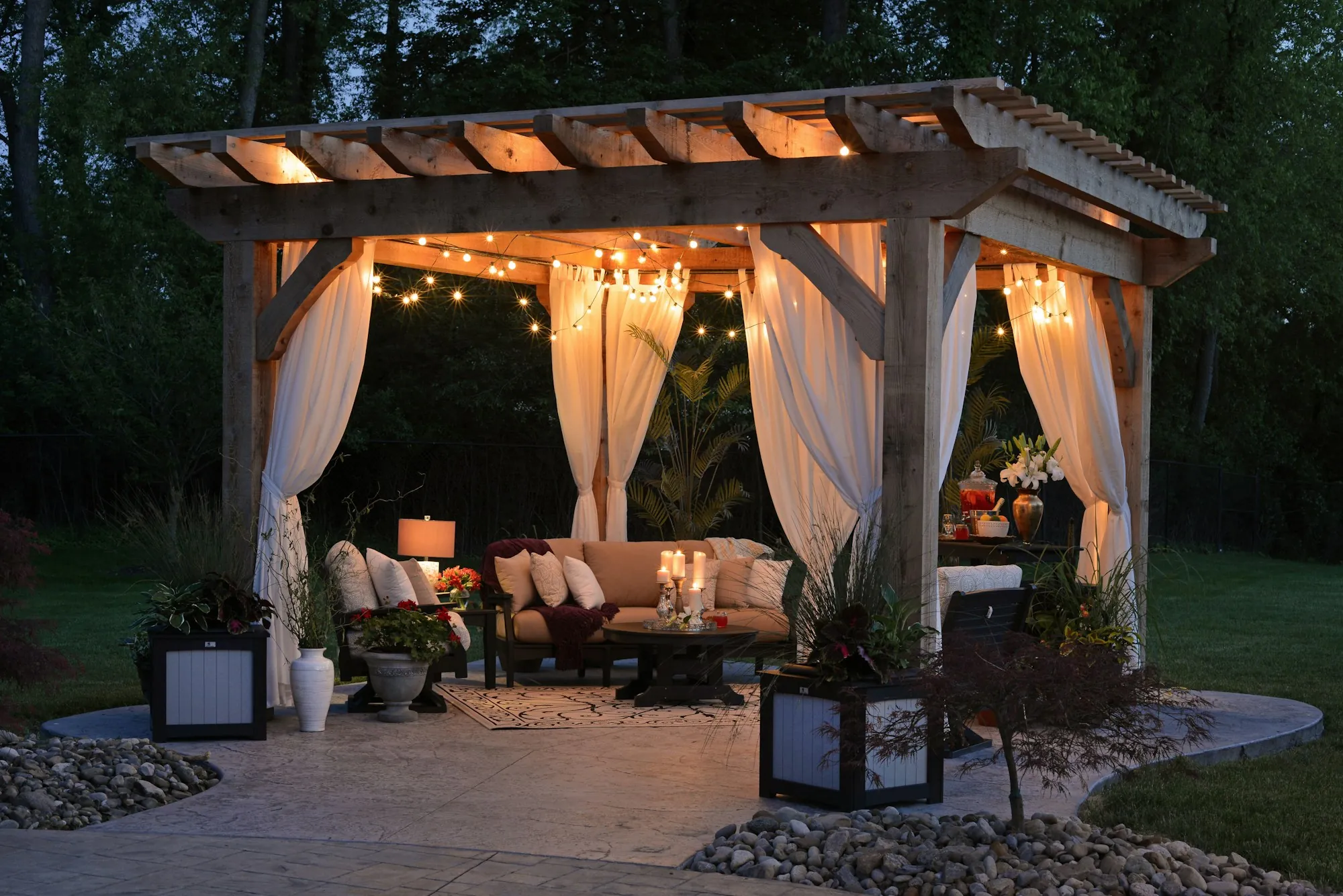 Backyard gazebo with string lights and seating at dusk